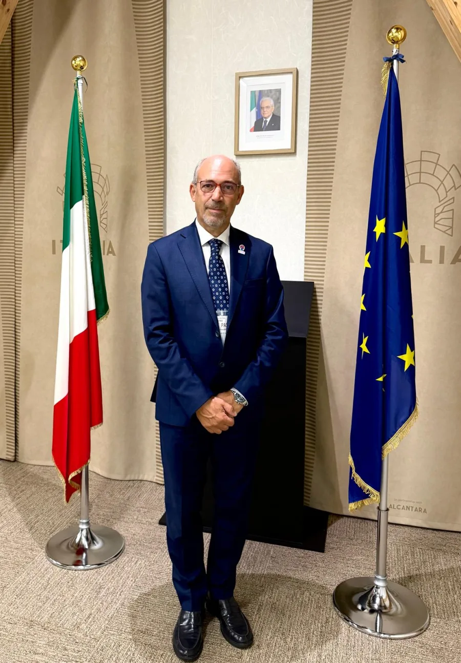 Carlo Dugo in un contesto istituzionale tra la bandiera italiana e quella europea